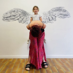 Enfant avec des ailes dans le dos sur le dos d'une adulte