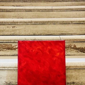 Photographie d'un monochrome rouge de Karine Corbier posé dans les escaliers en bois peint très anciens au château de Gieres