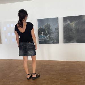 Photographie de Karine Corbier de dos devant diptyque nuage de l'exposition COrbier Arino