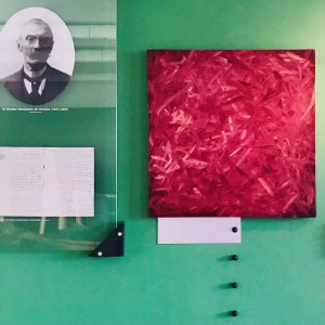 Peinture monochrome rose exposée sur un mur vert