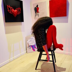 Femme en position inconfortable sur une chaise devant les tableaux d'exposition Un tableau représente la même personne au collant rouge dans la même position